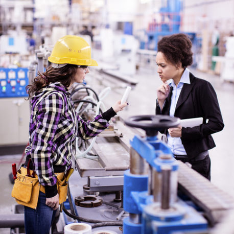 Girl in a factory working with her woman boss